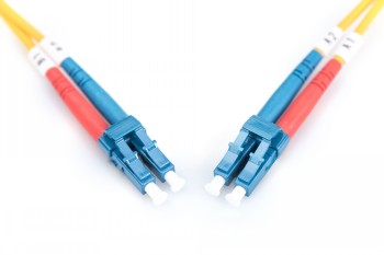Digitus FO Patch Cord, duplex-LC, 1 m, gula kablar och blå kontakter Två gula duplex-LC-typ fiberoptiska kablar med en längd på 1 meter, med blå kontakter på vit bakgrund.
