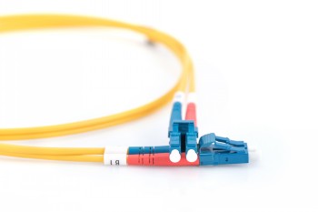 Digitus FO duplexfiberkabel med LC-kontakter, 1 m Gul duplexfiberkabel med blå LC-kontakter och färgkodade hylsor på vit bakgrund.