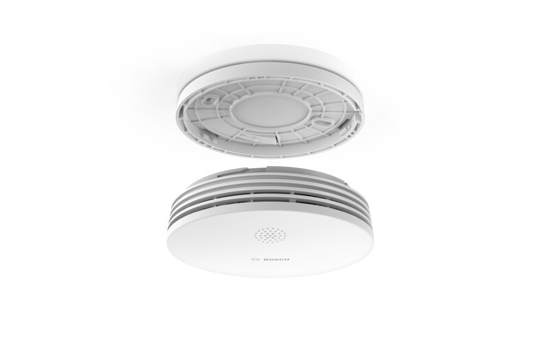 Bosch-brandvarnare II med avtagbart lock Rund vit Bosch-brandvarnare med avtagbart lock och ventilationsöppningar, fotograferad från sidan.
