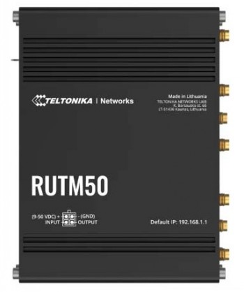 Svart Teltonika RUTM50 IoT-router med anslutningar och logotryck, fotograferad uppifrån på en jämn yta.